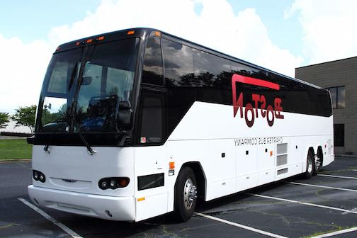 a plain white charter bus with a "波士顿包车 Company" logo